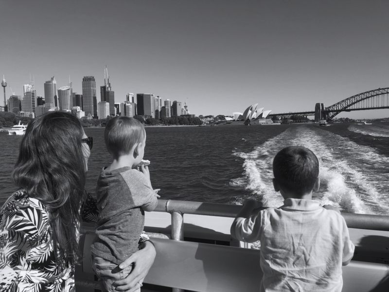 A mother and her children on a boat overlooking Sydney Harbor in Australia