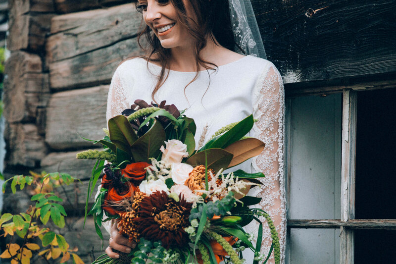 bride by old building with bouquet of flowers