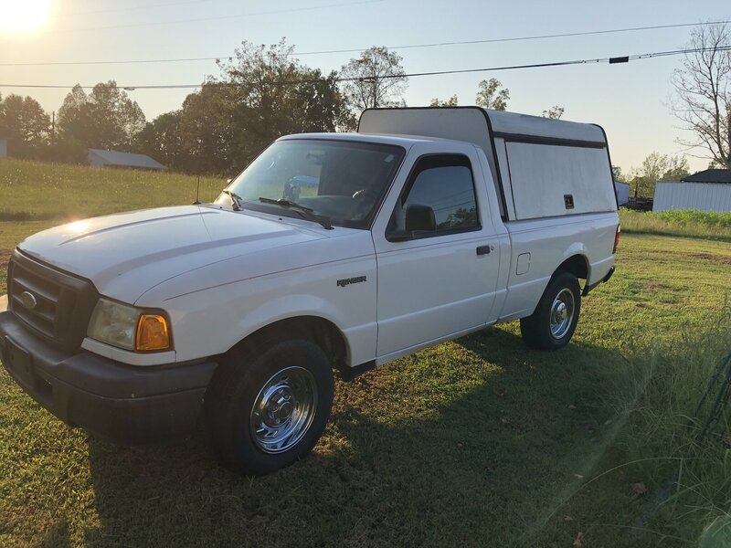 Black and white image of mom kissing newborn baby on forehead