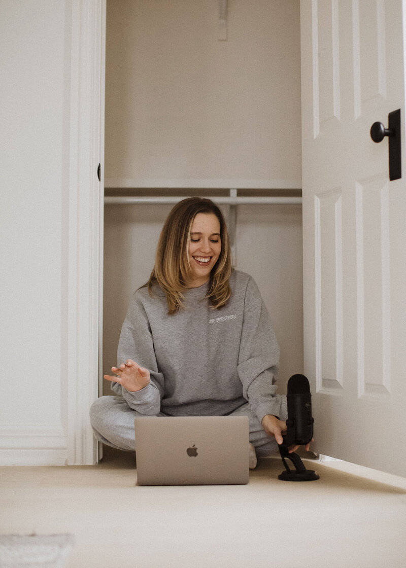 girl with grey sweatshirt and podcasting equipment on floor