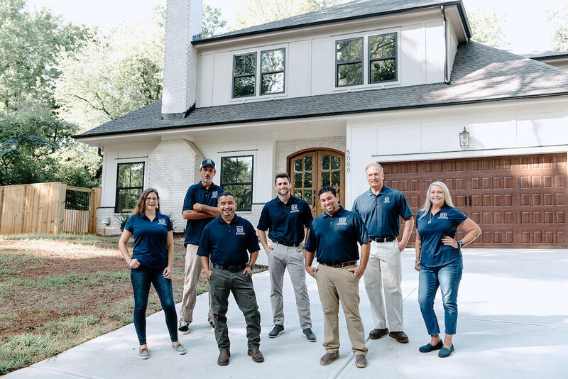 Team photo of Hallmark building group in driveway of new home