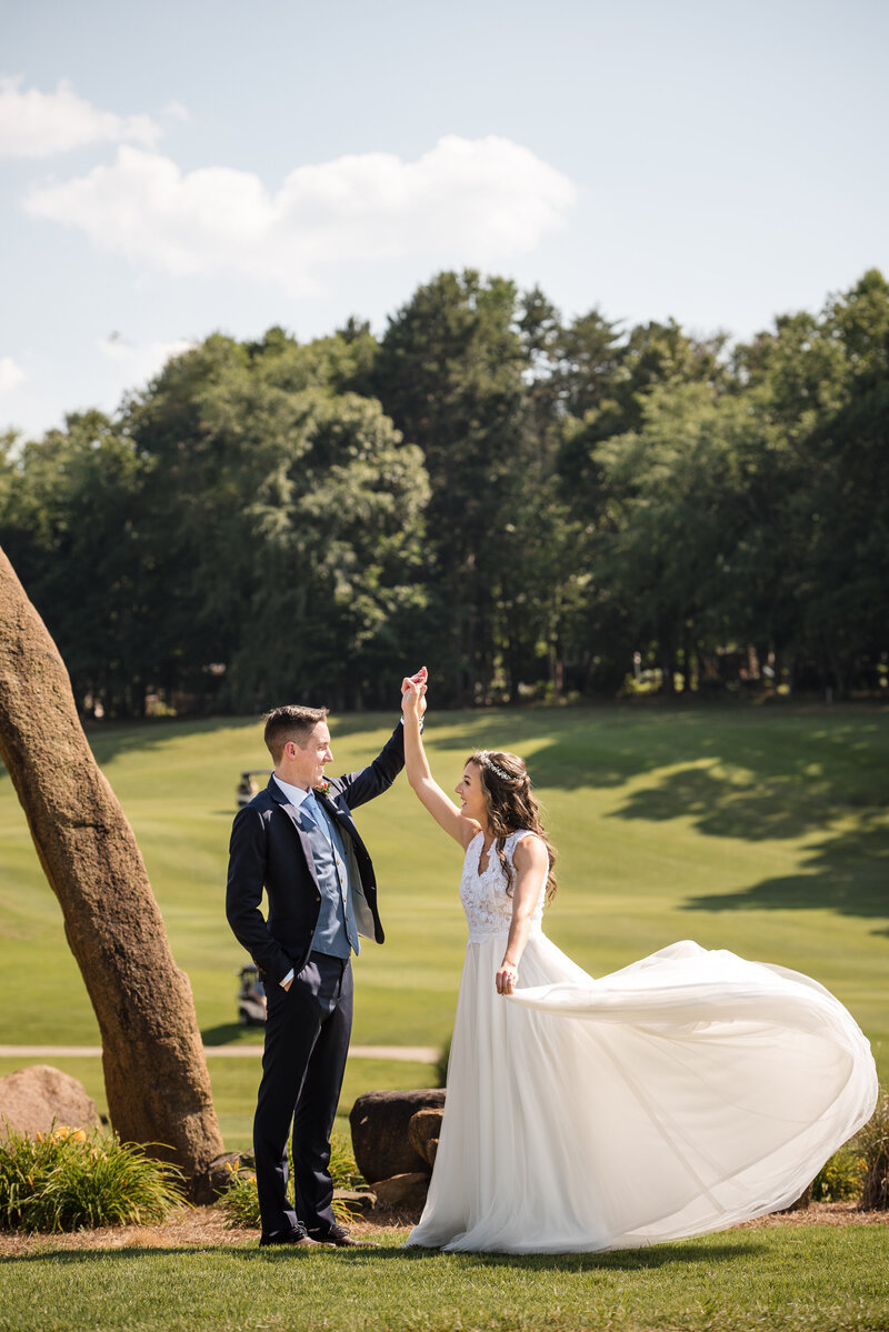 Bride and groom dancing next to the stone sculpture on the golf course at NorthStone Country Club by Charlotte wedding photographers DeLong Photography