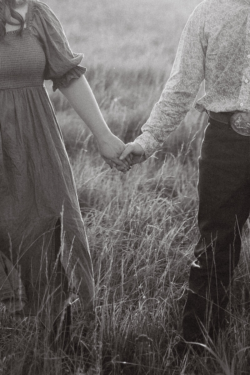 couple photo| couple poses| country couple photoshoot| Kansas couple photographer|couple holding hands in field during couples photoshoot. 