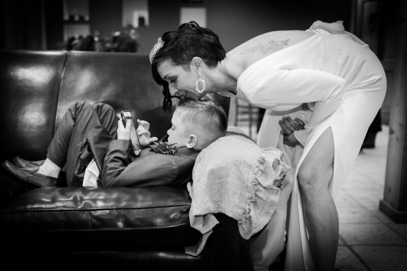 Bride kisses little boy on couch