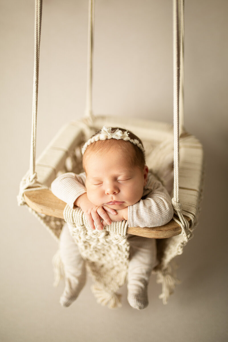 sleeping newborn in a swing