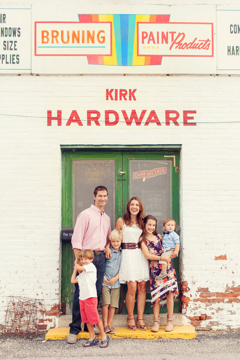 Family of 5 in colorful clothes standing in front of a colorful building in Noblesville.