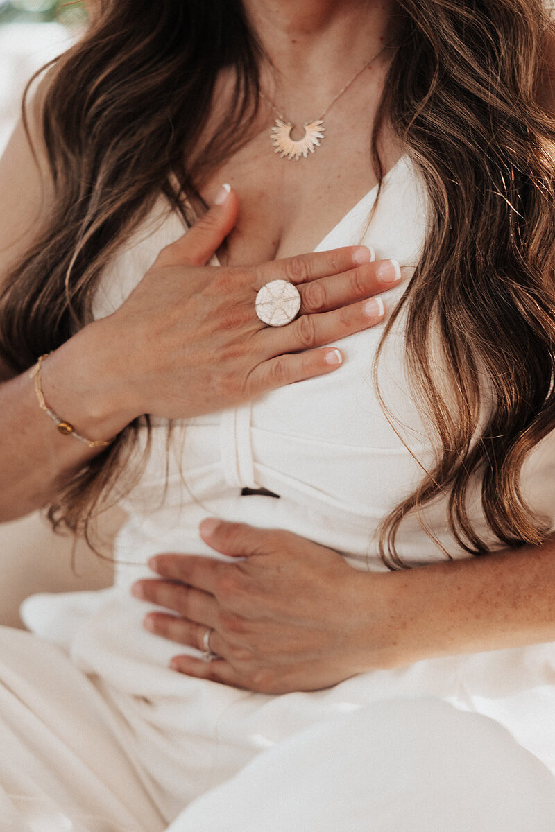 a woman with her hands over her chest and belly