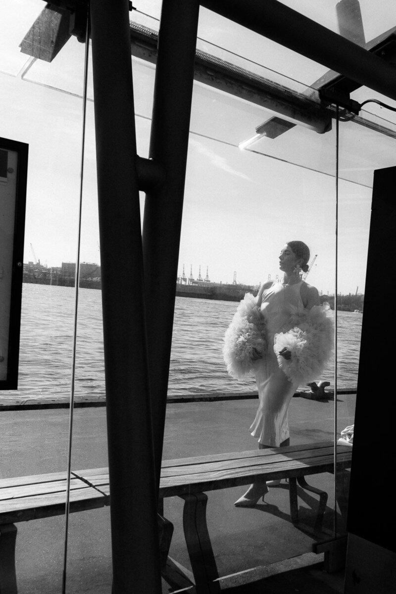 Elegante Braut mit Tülljacke beim Editorial Shooting an der Hafenkante mit maritimer Kulisse 