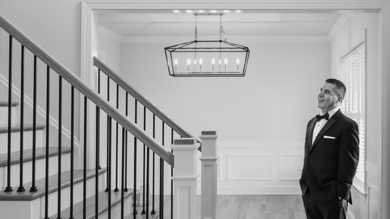 Father of the bride waiting at the bottom of the stairs, a heartfelt and emotional moment captured in a real style.
