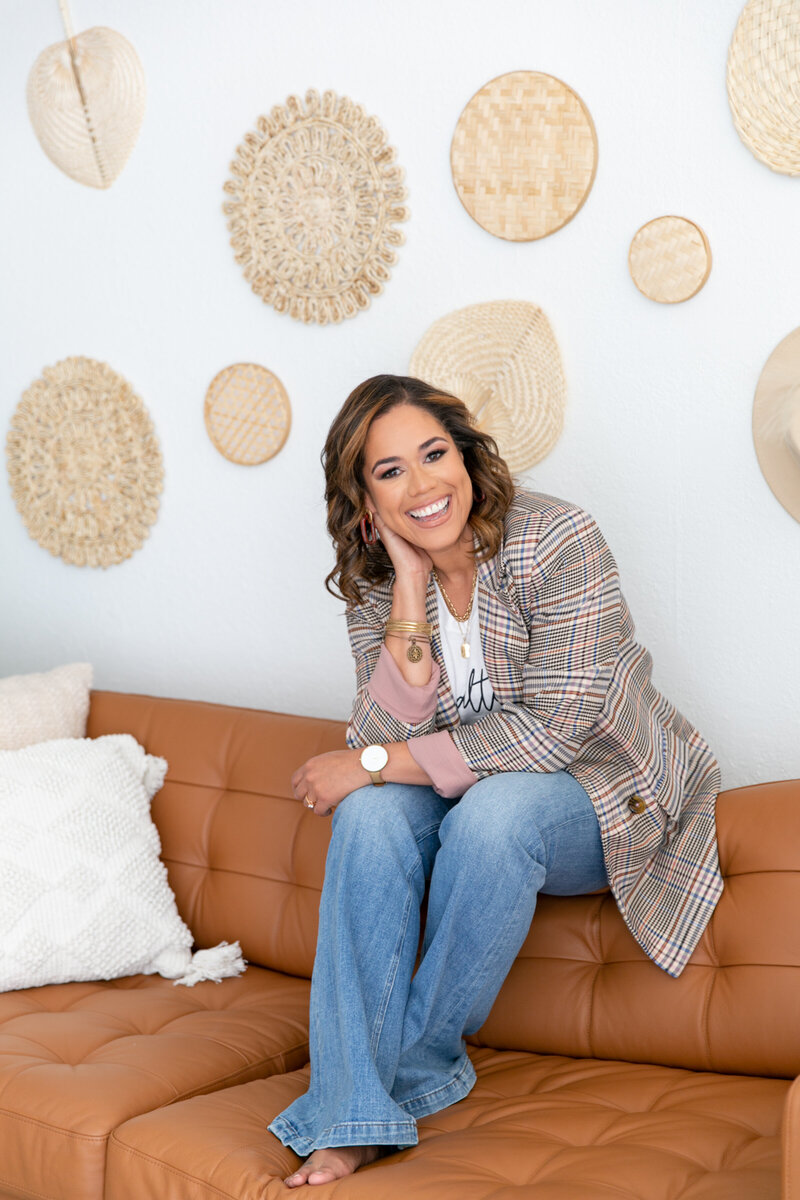 latina realtor sitting down on brown couch