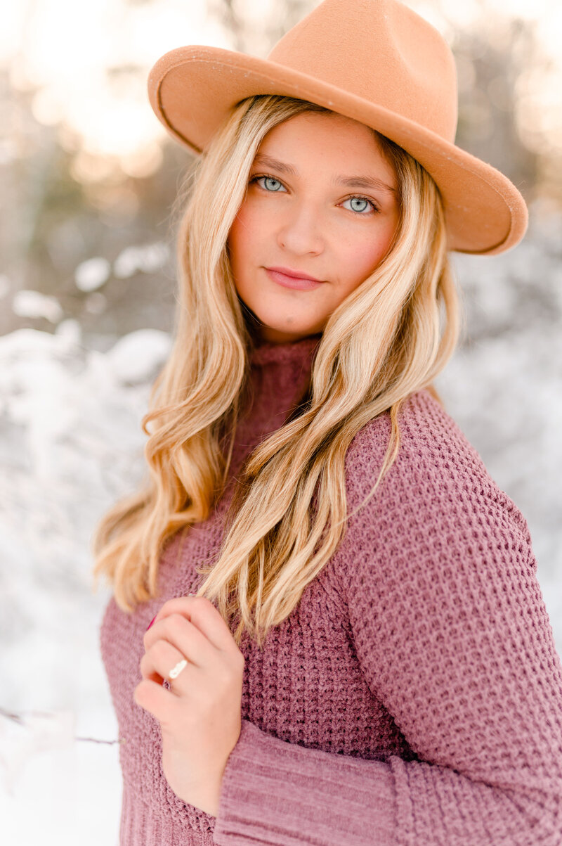 Photo by Massachusetts senior portrait photographer Christina Runnals | Senior pictures of girl with long blond hair wearing hat in snow