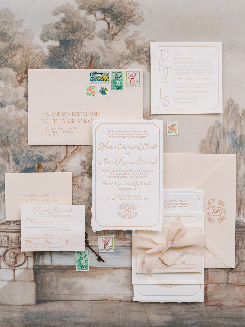 A flat lay of custom wedding invitation suite in neutral and pastel shades, representing customized calligraphy by Life in letters.