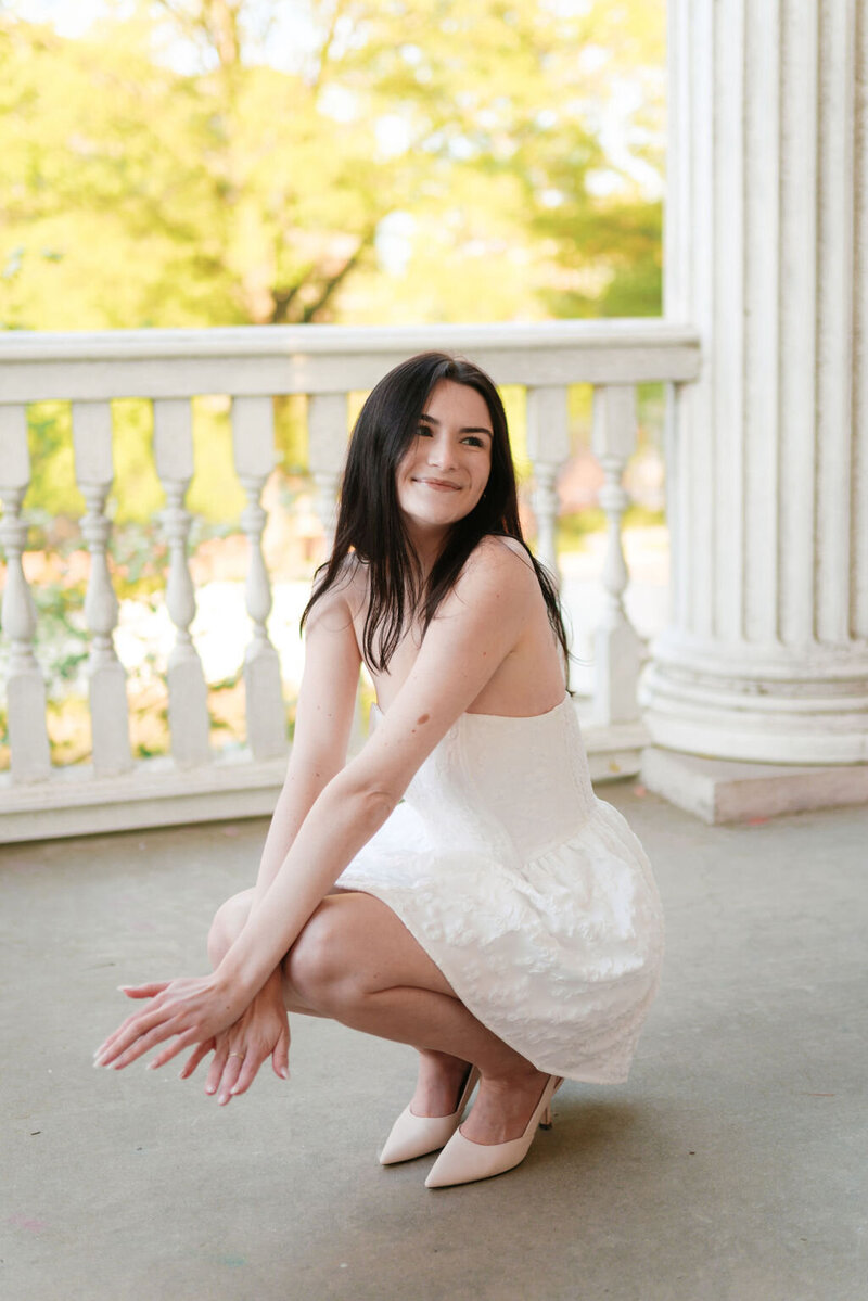 girl in white dress smiles at the alumni house in knoxville tennessee during university of tennessee graduate photos
