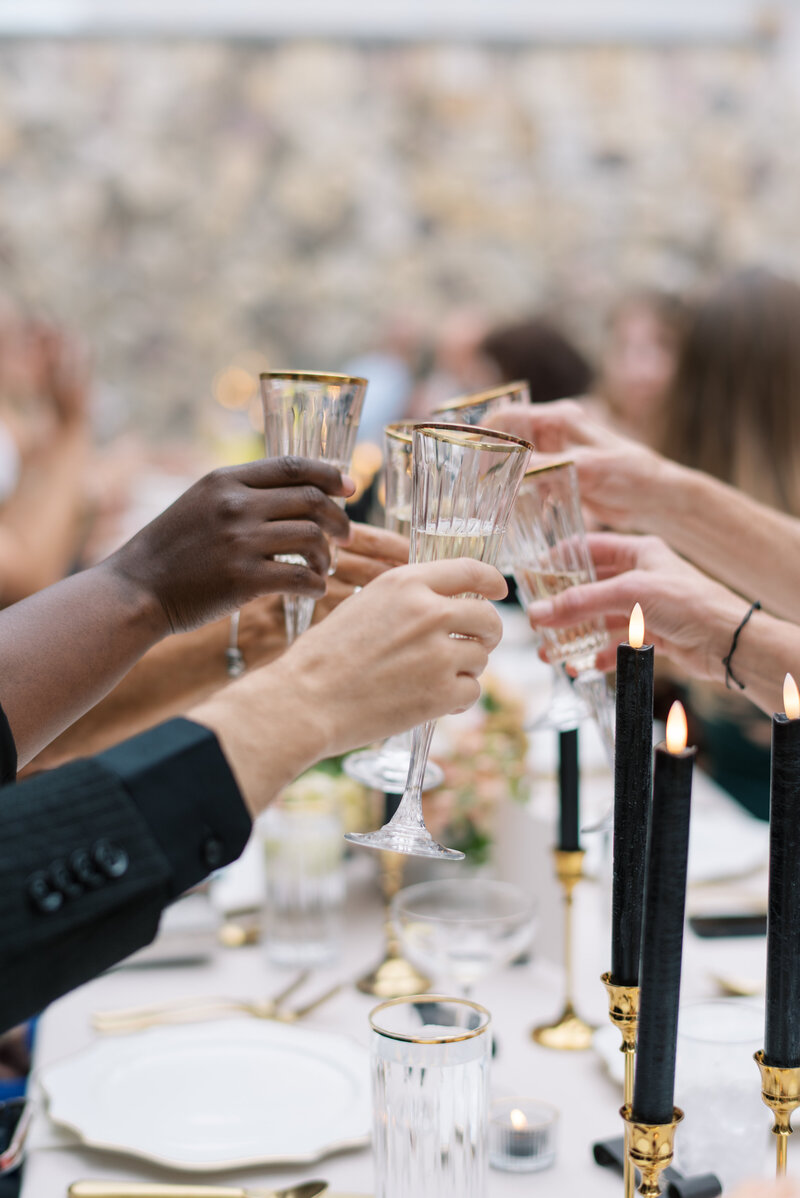 wedding guests cheers champagne glasses over table