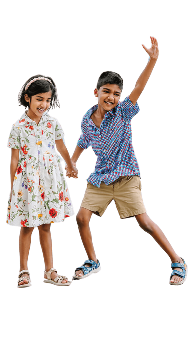 Brother and sister holding hands, with the boy raising his hands in a playful pose during a Paris family photoshoot on Île Saint-Louis in the city center.