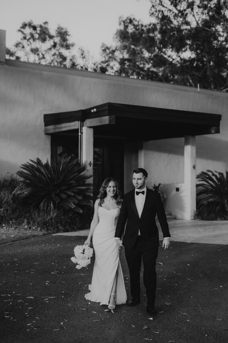 Wedding Photography thats a Vibe in the Hunter Valley. Natural and relaxed Black and white wedding photo of a couple walking and smiling at Tower Lodge near Pokolbin in the Hunter Valley