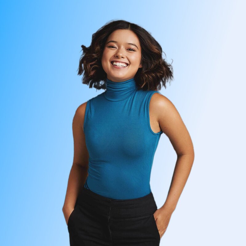 Girl with happy energy against a blue white gradient. She's wearing a turquoise halter neck.