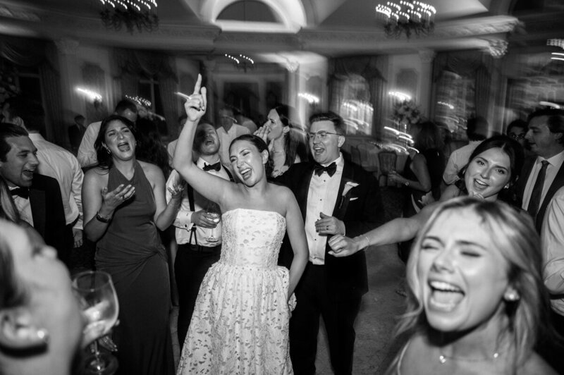 A wedding party cheers as the bride and groom kiss in the Bonnet Island Estate Chapel. A burnt sienna and tan color scheme