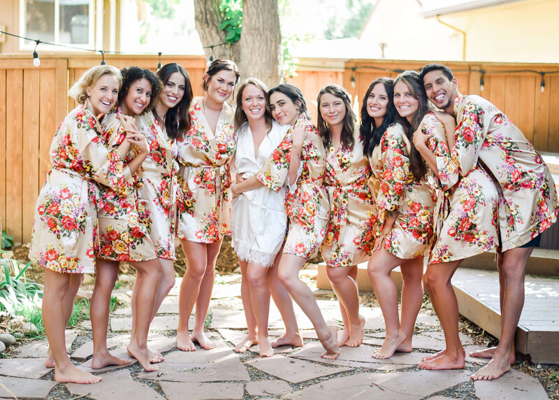bridal party poses together in matching floral robes
