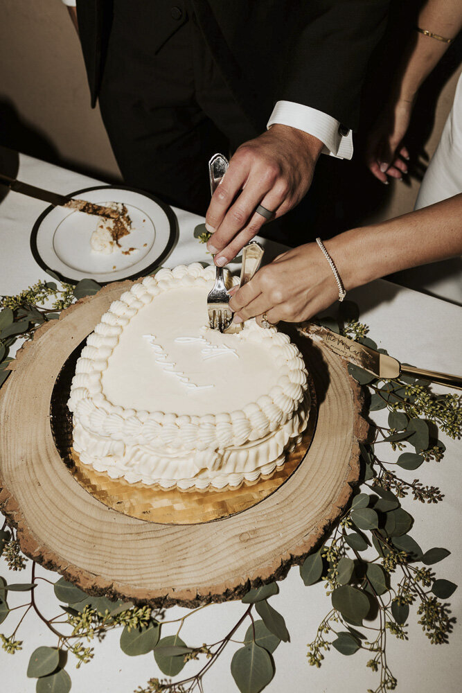 bride and groom taking a piece of their wedding cake