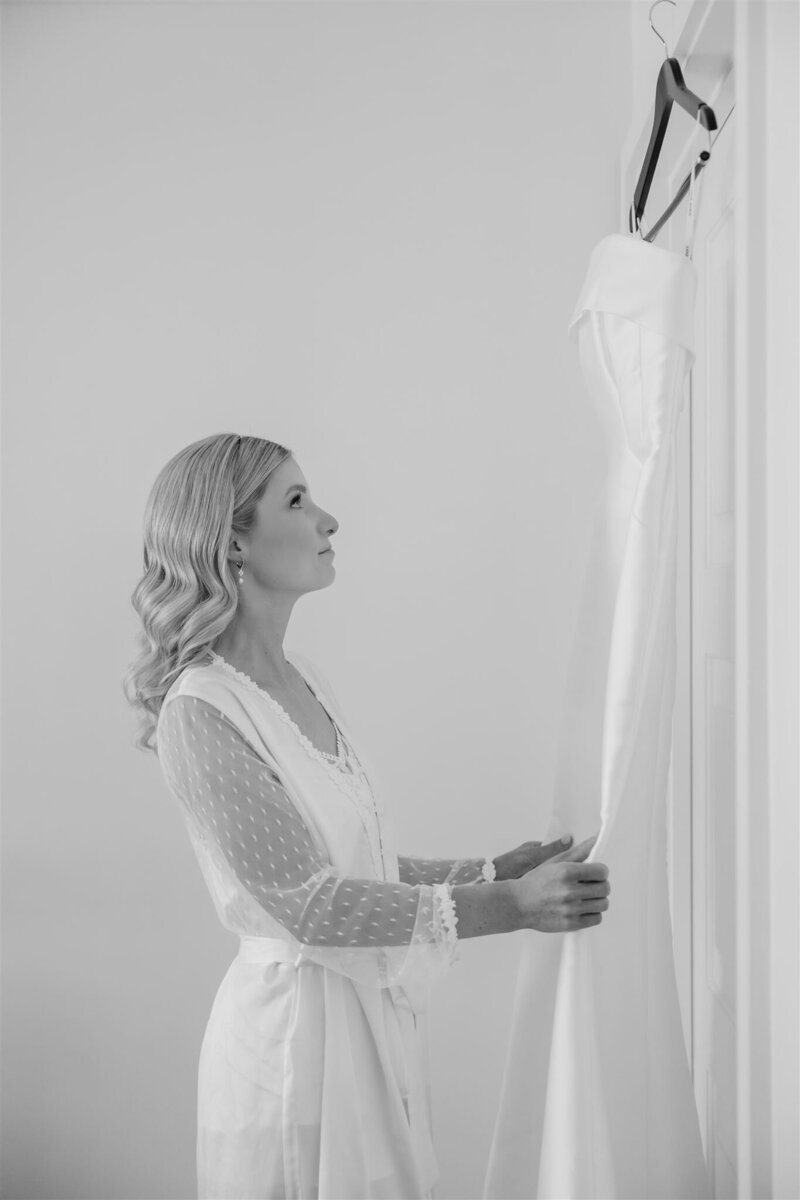A black and white photo of a bride looking at her wedding dress at the Alfond inn, winter park. 