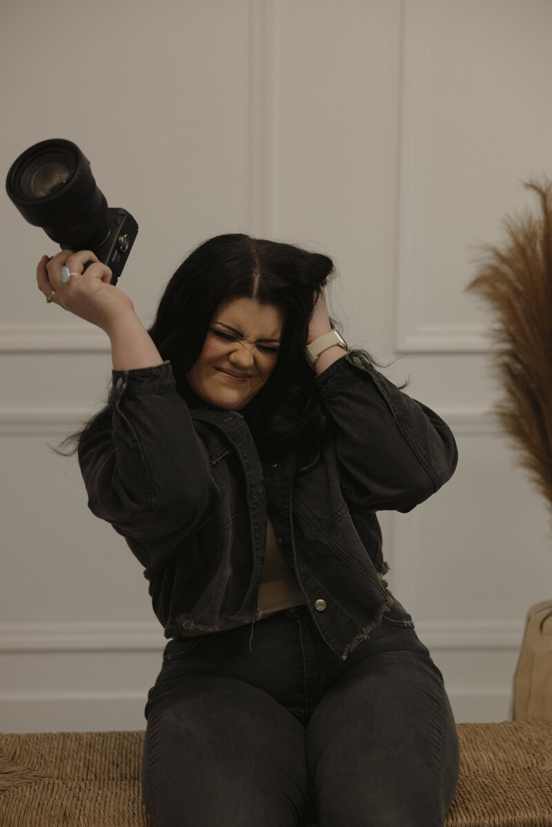Brigette holding her camera up in the air and having a smiley expression.