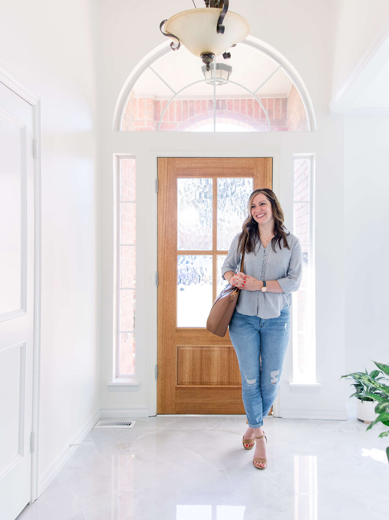 woman in bright entryway holding a briefcase