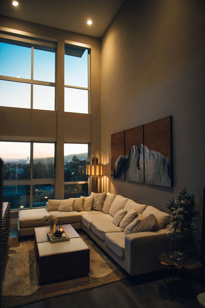 Living room with a large sectional couch and paintings on the wall