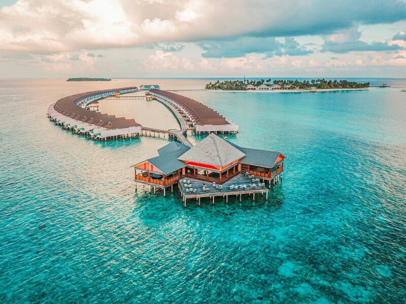 Over water bungalows on an island by luxury travel concierge services