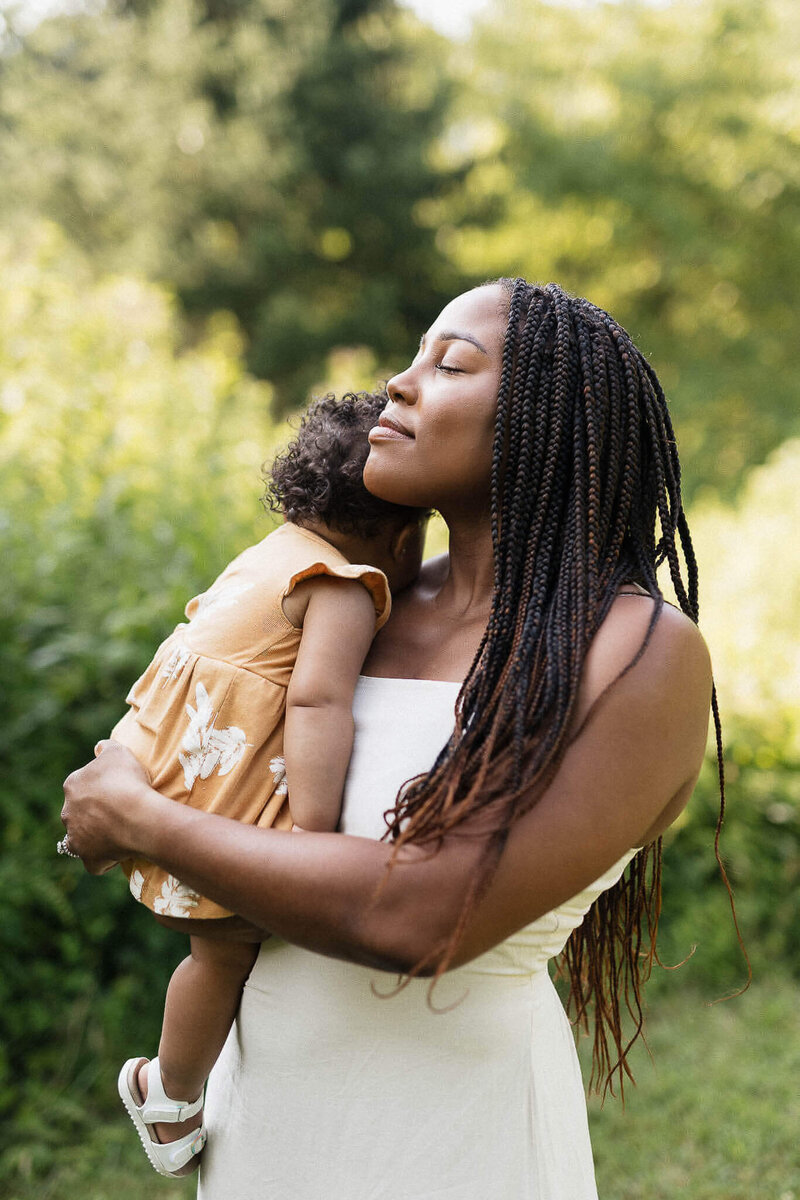 A serene moment of a mother holding her child in a Cleveland park. Emotional and timeless family photography.