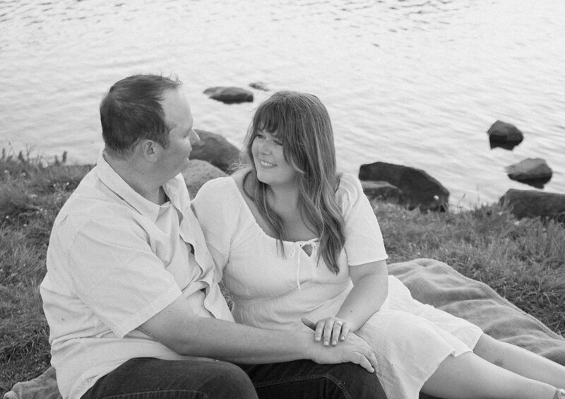 engaged couple embrace by the ocean