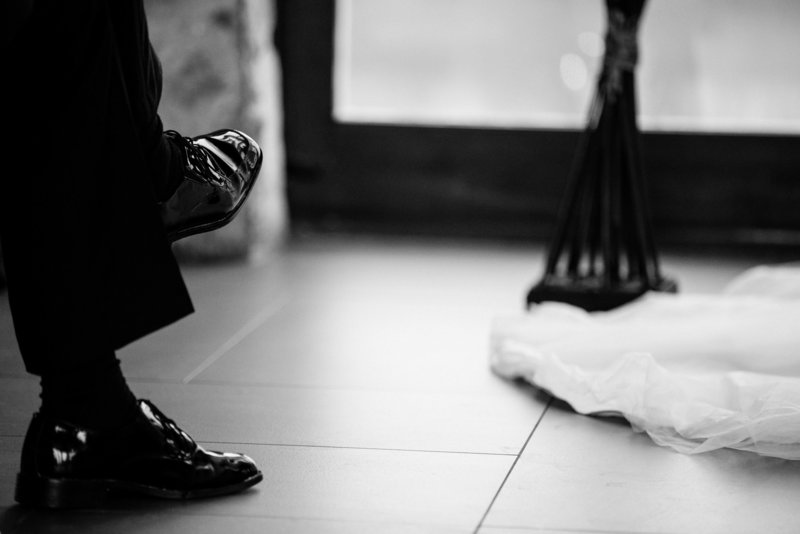 Grooms shoes with bottom of wedding dress black and white