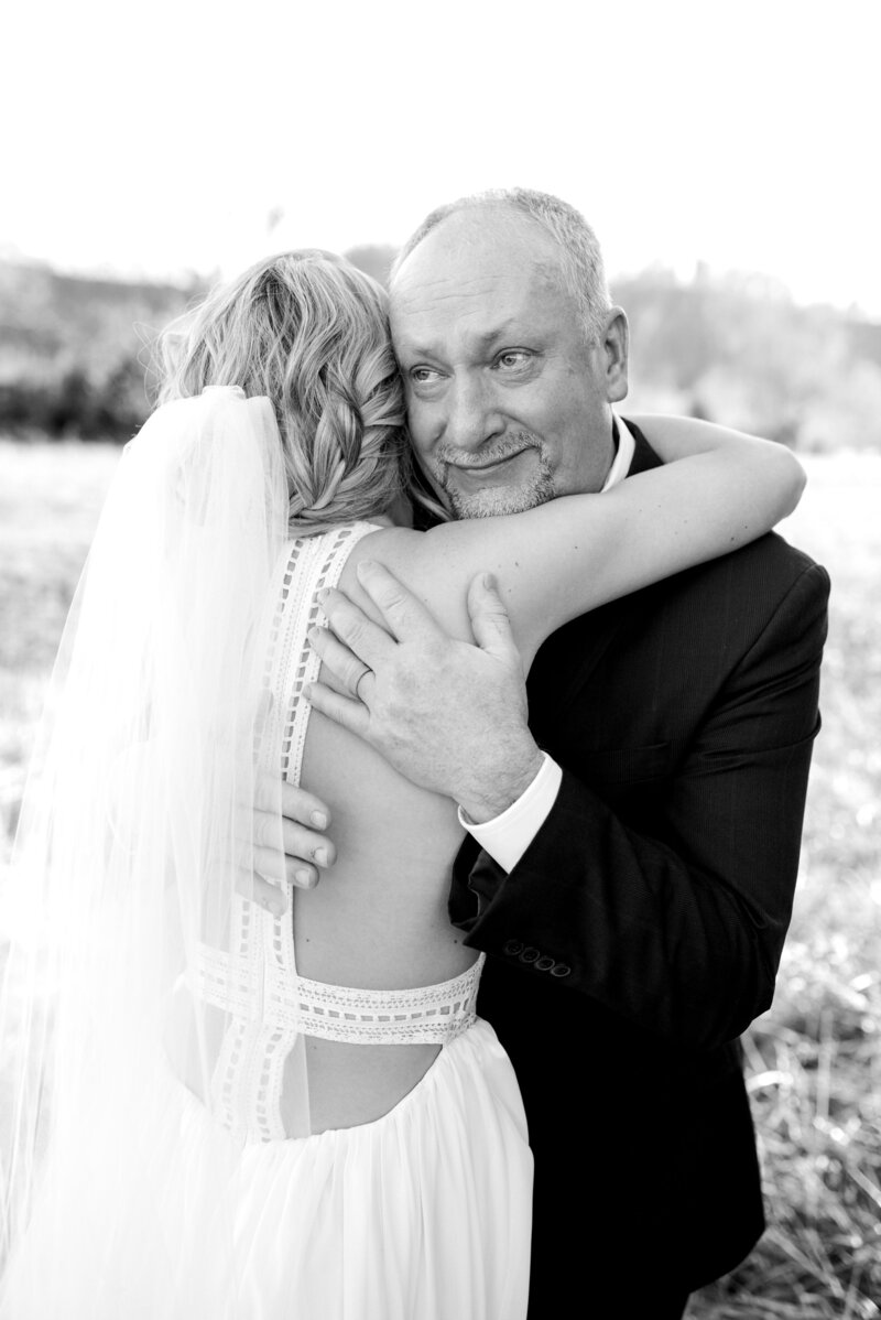 Father of the bride hugging his daughter in a  black and white photo