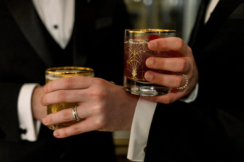 two grooms toasting glasses
