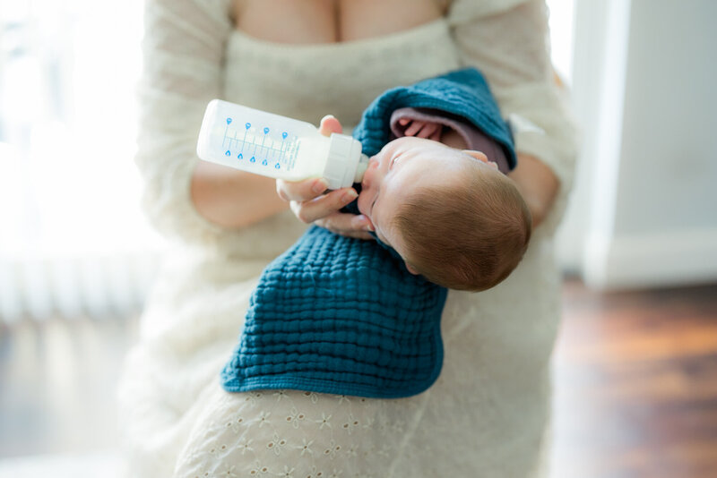 Baby girl swaddled in a moses basket in a in-home newborn session captured by a Tampa portrait photographer.