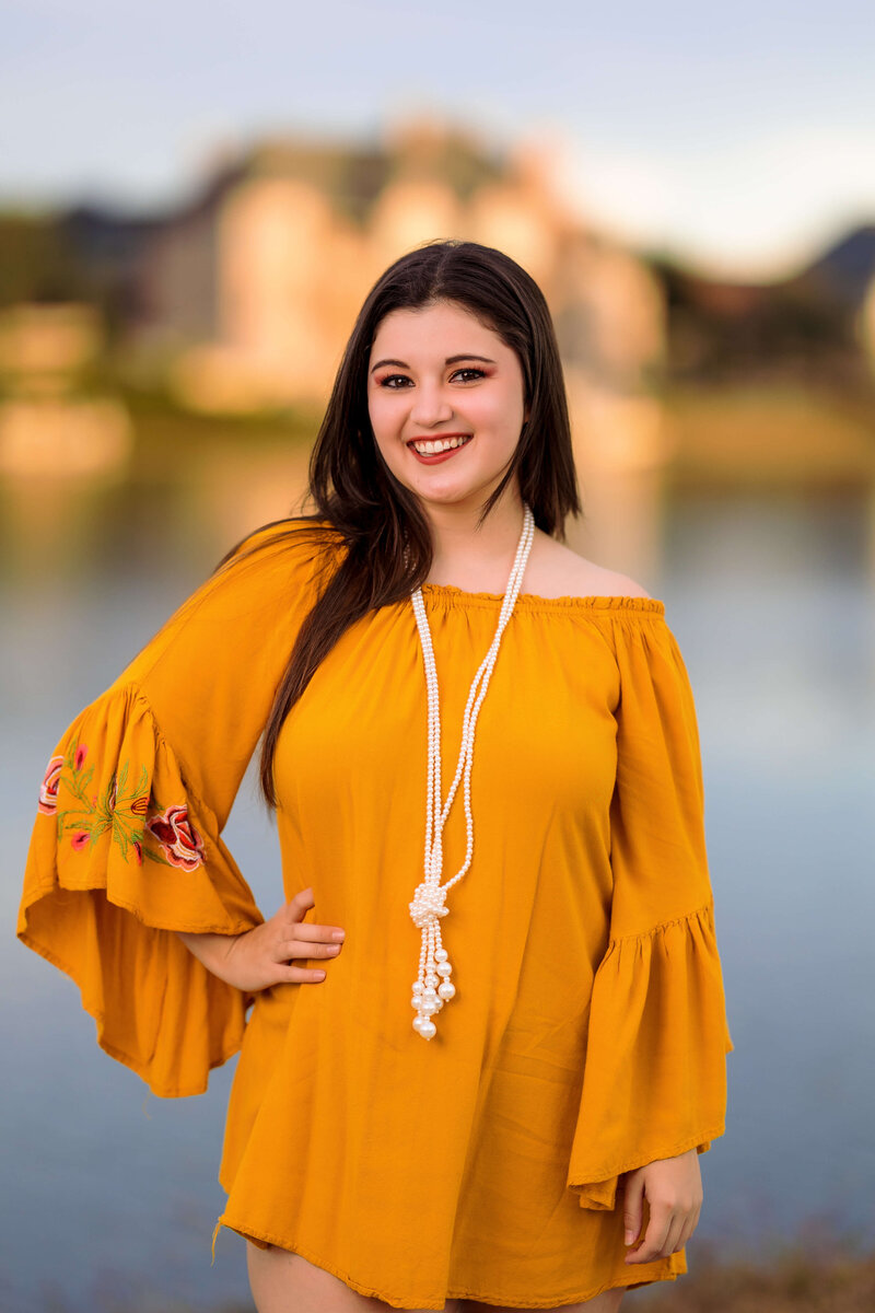 high school senior poses for photos in yellow dress