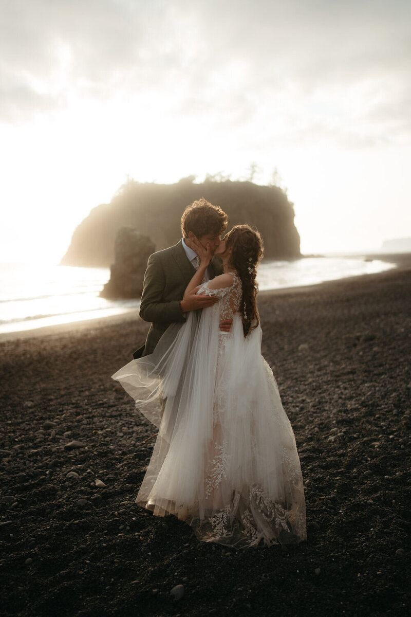 A married couple kisses on their wedding trail in Washington at sunset