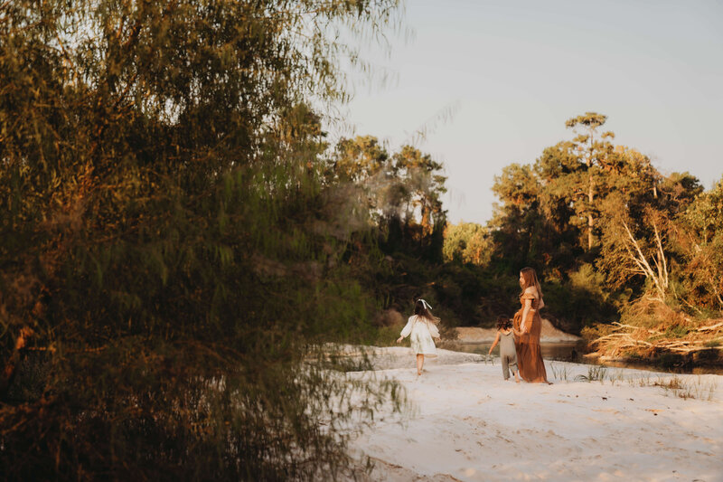siblings playing in the sand during a family session in The Woodlands, Texas