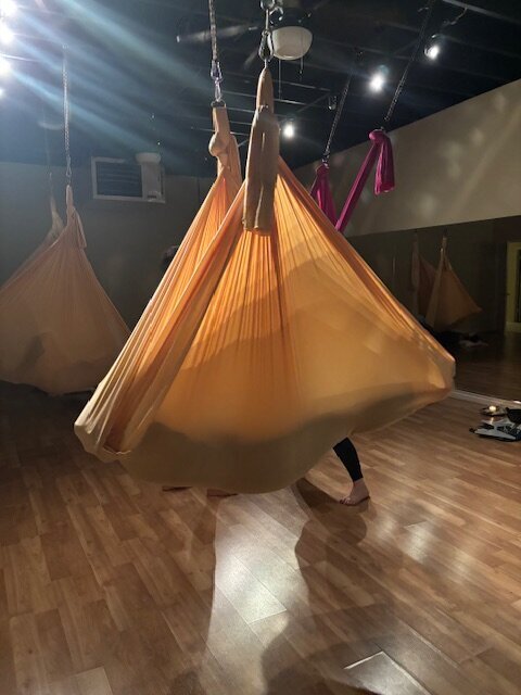 Image of Keri Nola using aerial somatic healing with someone in a blue silk hammock