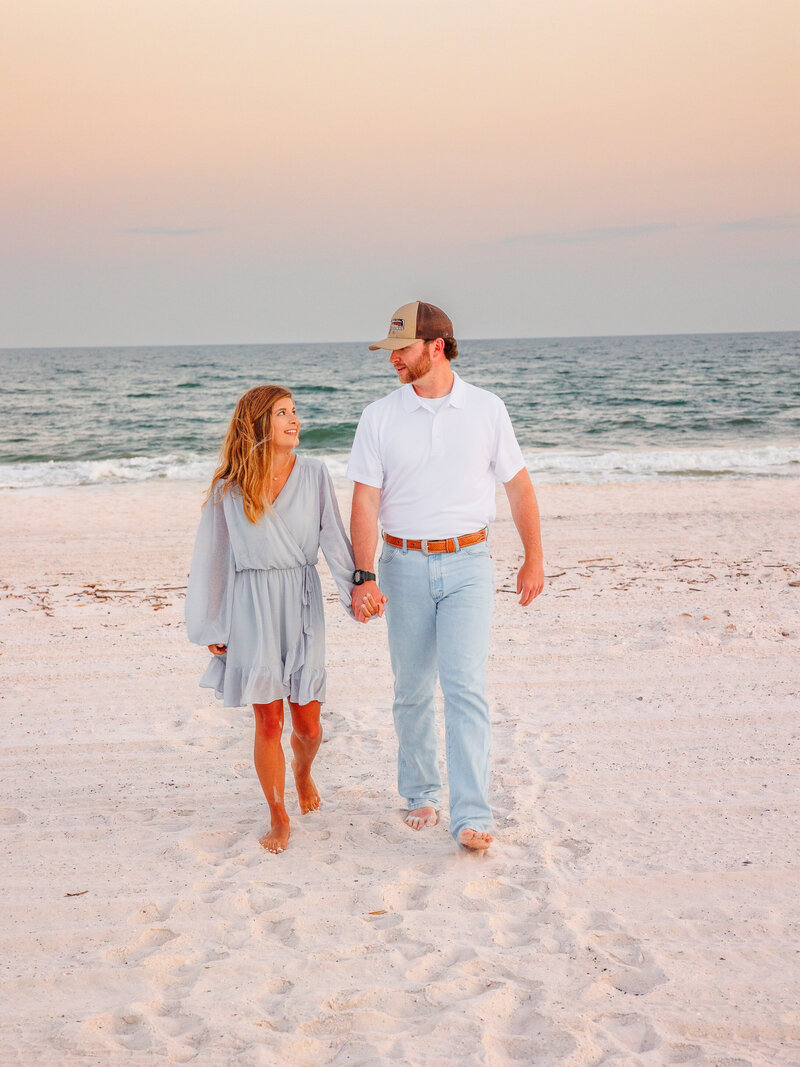 Authentic look for each other as couple walks along the sand