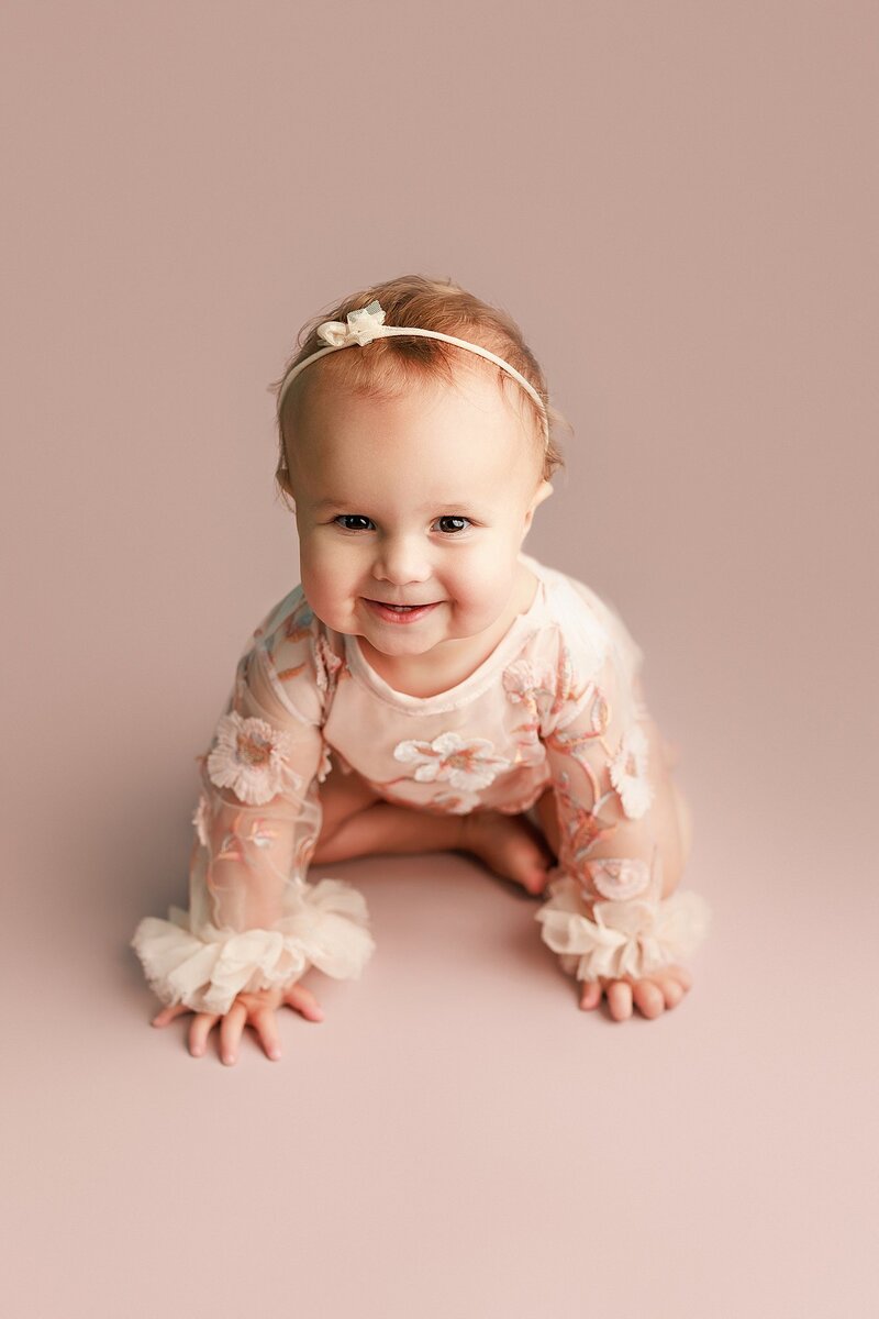 Baby flashing a big smile during joyful milestone photo session