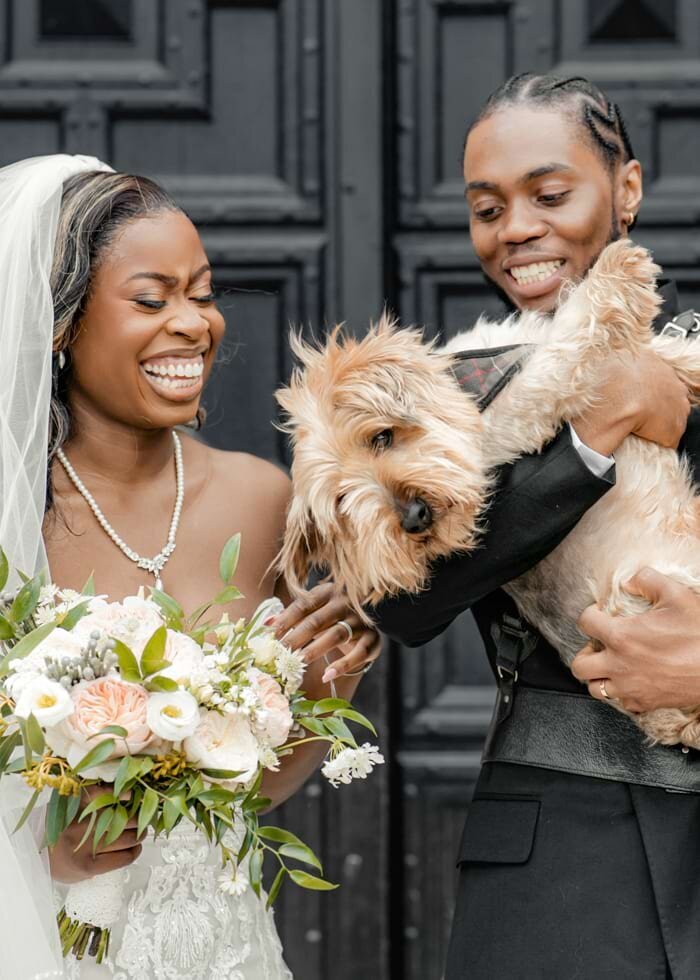 Yorkshire Wedding Photographer & Videographer capturing a joyful bride holding her dog at Broome Park Hotel, Canterbury.