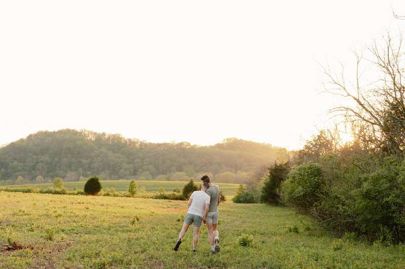 couple holding hands and walking at sunset