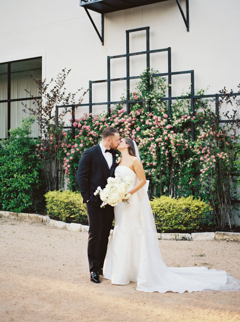 Fun film photographer smiling and laughing at camera with floral bouquet