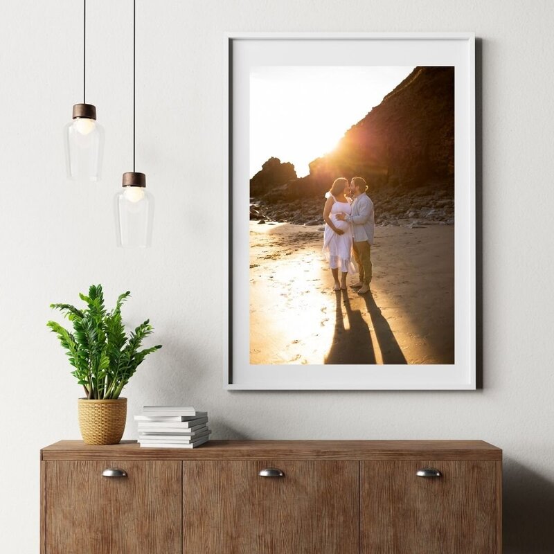 Oregon maternity photographer shows framed photos from recent motherhood session.