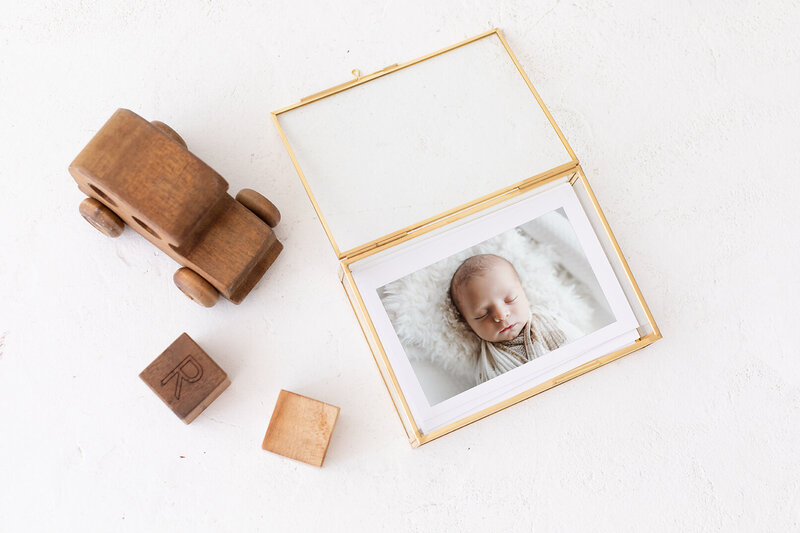gold and glass print box holding a print of a newborn boy