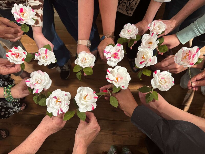Hands holding Smith's Parish roses in paper