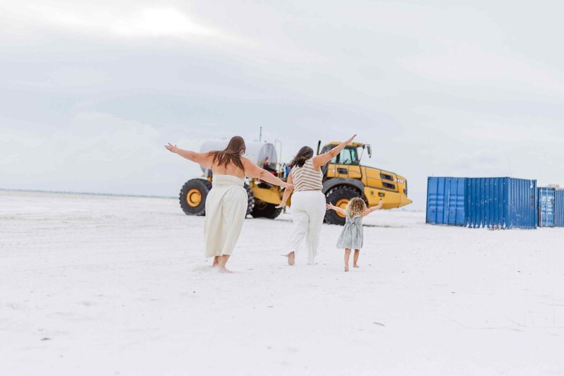 Family runs toward a heavy equipment truck with airplane arms