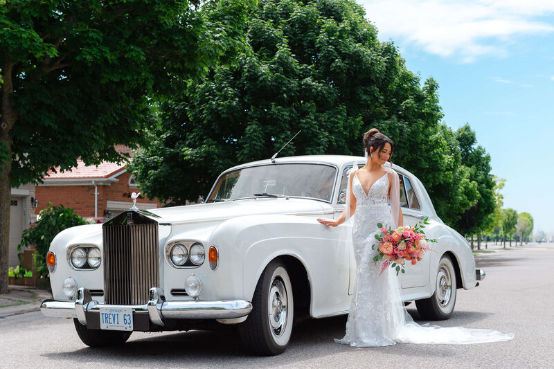 a photo of a bride standing beside a vintage white car captured by Ottawa wedding photographer JEMMAN Photography