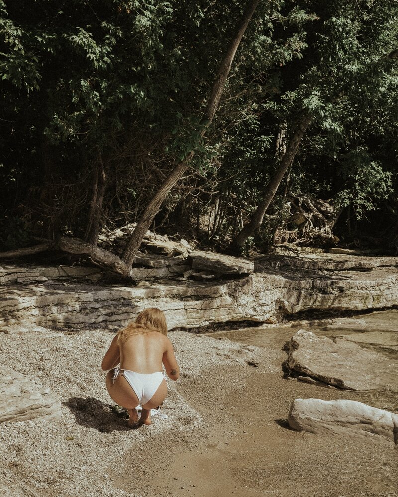 girl looking for shells on the beach